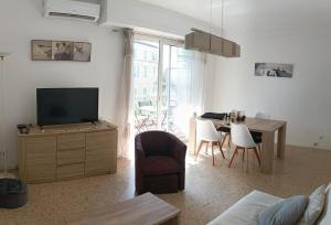 een woonkamer met een televisie en een tafel en stoelen bij T2 calme centre ville in Corte