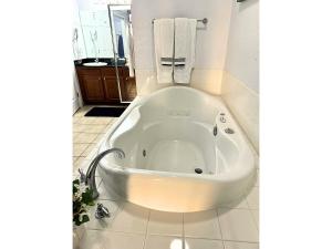 a white bath tub in a bathroom with a sink at Pirate Ship Resort Condo in Orlando +7 photos