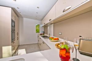 a kitchen with a counter with a drink in a glass at Villa Kmar by Villa Plus in Cumbre del Sol