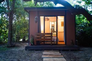 a small cabin with a bench in the woods at Idly Lodges in Punta del Este