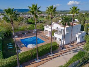 ein Luftblick auf ein Haus mit einem Pool und Palmen in der Unterkunft Villa near Ibiza Town sleeps 8 in Can Furnet