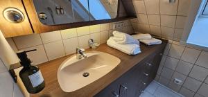 La salle de bains est pourvue d'un lavabo et d'une bouteille de savon. dans l'établissement Nordic Vintage Cottage - ComfyHome Apartments Stuttgart, à Stuttgart 55 autres photos