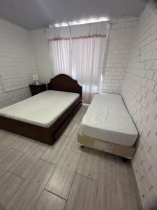 a bedroom with two beds and a window at Casa tijolo a vista in Bombinhas