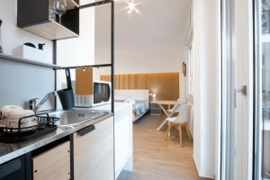 a kitchen with a sink and a bed in a room at Gaia Station in Bari