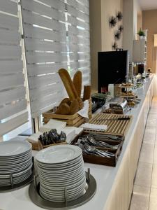 un buffet con piatti bianchi su un bancone di Siviris Golden Beach a Siviri