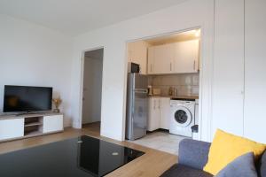 a living room with a couch and a kitchen at Bel appartement T2 cosy in Colombes