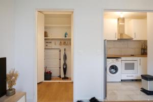 a kitchen with a washer and dryer at Bel appartement T2 cosy in Colombes +1 photo