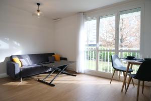 a living room with a couch and a table at Bel appartement T2 cosy in Colombes