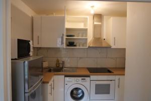 a kitchen with a sink and a washing machine at Bel appartement T2 cosy in Colombes