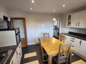 a kitchen with a wooden table and chairs in it at Anchor Gardens Villa in Lindal in Furness