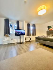 a living room with a bed and a flat screen tv at Ferienhaus "Sofia" Anno 1650, NEU - Top Lage - Tempur Beds - WIFI - Parking - im Herzen von Detmold-Altstadt, Historische Stadtmauer, Old lane Detmold in Detmold