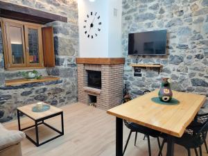 a living room with a table and a stone wall at Apartamento Rural Malkorpe in Lekunberri