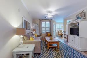 a living room with a couch and a tv at Creekwood --- 1400 Pebble Dr #1410 in The Plantations