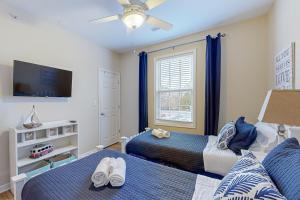 a bedroom with two beds and a flat screen tv at Creekwood --- 1400 Pebble Dr #1410 in The Plantations