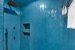 a blue tiled bathroom with a shower with a glass door at Little Blanca in Canyon Lake +20 photos