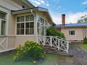 a home with a porch with a white railing at Utajärven Pappila Olden Vicarage in Utajärvi