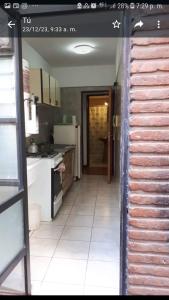 a kitchen with a stove and a white tile floor at Susana in Mar del Plata