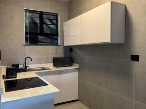 a kitchen with white cabinets and a sink at Ridge Royal in Amanzimtoti