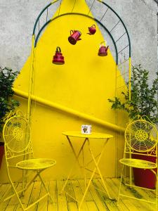 a yellow wall with two chairs and a table at Wonderland21 - B&B - Séjour féerique à 7 min Disneyland Paris in Saint-Germain-sur-Morin