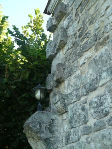 a lamp on the side of a stone wall at Chateau de la Vieille Chapelle in Lugon et l’Ile du Carney