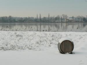 a barrel sitting in the snow next to a body of water at Chateau de la Vieille Chapelle in Lugon et l’Ile du Carney
