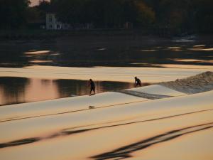 two people walking in the sand on the beach at Chateau de la Vieille Chapelle in Lugon et l’Ile du Carney