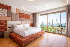 a bedroom with a large bed and a large window at LE BLEU RESORT in Tangier