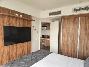 a bedroom with a bed and a flat screen tv at Flat Hotel Guarulhos Aeroporto GRU in Guarulhos