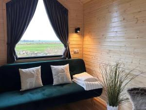 a green couch in a room with a window at Little Harmony House by Tiny Away in Jægerspris