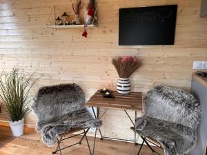 a room with a table and two furry chairs at Little Harmony House by Tiny Away in Jægerspris +5 photos