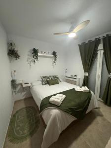 une chambre avec un lit et un ventilateur de plafond dans l'établissement Casa Rural Fuente la Teja, à Espinosa de Henares