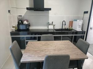 a kitchen with a table and chairs in a kitchen at RINA HOMESTAY Kemaman in Cukai