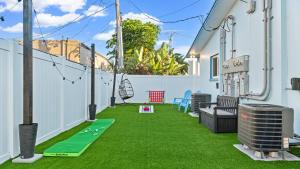 a patio with green grass on a house at The Shark Tank Cocoa Beach - Retro Florida, Downtown, 5-Min Walk to Beach, Shops & Bars in Cocoa Beach