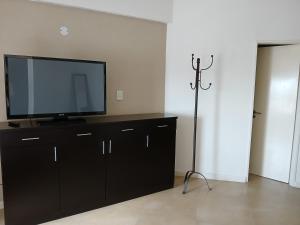 a living room with a flat screen tv on a dresser at Departamento Studio Plaza Río Grande - Tierra del Fuego in Río Grande