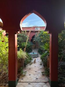 an archway leading into a garden with a dog in it at Riad Beldi by MaHa in Oulad Teima
