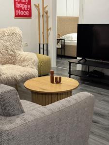a living room with a tv and two chairs and a table at Apartman Laros in Split