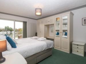 a bedroom with a large white bed and a window at White Gables in Horning
