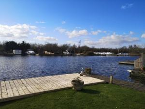a dock on a lake with a bird on it at White Gables in Horning