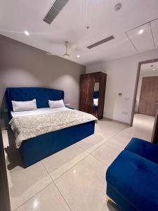 a bedroom with a blue bed and a blue couch at Luxe 2 BHK with Stunning Views in Gurgaon +30 photos