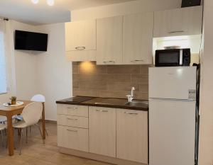a kitchen with a white refrigerator and a table at Friedrich Apartments in Merano