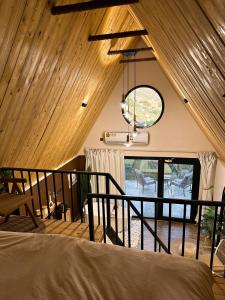 Habitación con cama y techo con ventana. en كوخ العُلا, en Misfāh