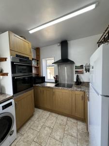 a kitchen with wooden cabinets and a stove top oven at The Moorings in Fairbourne