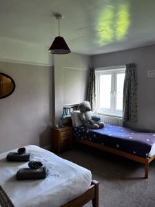 a bedroom with two beds and a teddy bear on the bed at The Moorings in Fairbourne +11 photos