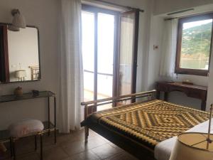 a bedroom with a bed and a mirror and a window at Del Sol E in Skopelos Town +35 photos