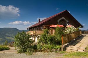 une maison avec des parasols sur son côté dans l'établissement Logis La Bouloie, à Bussang