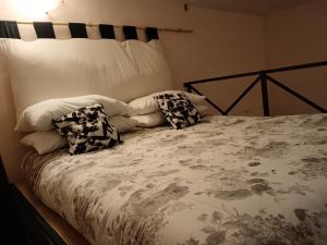 a bed with pillows on it in a bedroom at 'In My Place' Monolocale soppalcato Open space in Genzano di Roma