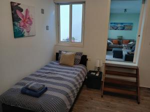a small bedroom with a bed and a living room at Spacious 3 Bedroom Apt Near the Sea in St Paul's Bay