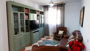a living room with a couch and a television at Palacete BARSANZ HOME in Alcalá del Valle