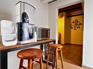 a kitchen with two wooden stools and a microwave at Discover Condesa Ideal Location in Mexico City
