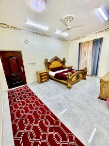 a bedroom with a bed and a red carpet at Shakir house in Ibri +6 photos